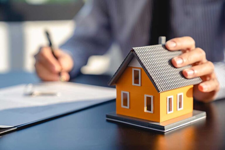 A couple walks through a bright home with a checklist while examining windows, floors, and kitchen cabinets.